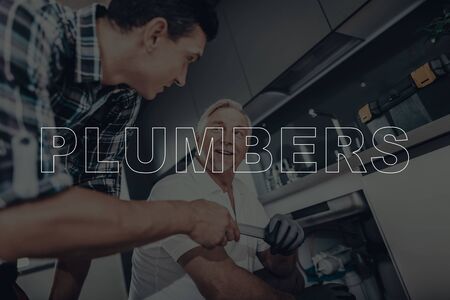 Two Male Plumbers are Working. Plumbers is Adult Guy and Old Man.  Men Wearing in a Special Uniform.の写真素材