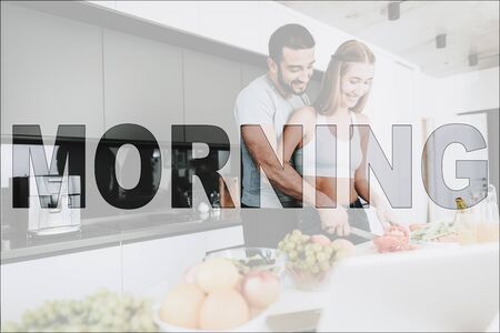 Happy Morning. Athletic Couple in the Kitchen. Vegetables and Fruits on Table. Laptop Computer on Table. Couple Prepare a Salad. Couple Cutting a Pepper. Couple Have a Healthy Lifestyle.の写真素材