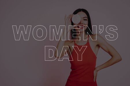 Girl in Red Dress. Pink Background. Celebrating Women's Day. March 8. Smiling Girl with Lollipop . Surprised Woman. Happy Woman. Happy Emotions. Woman Loves Lollipop. Beautiful Asian Woman.の写真素材