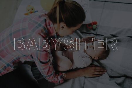 Happy Nanny Plays with Cute Baby. Baby Lying on Carpet. Smiling Nanny Wears Casual Clothes. Sweet Beautiful Caucasian Toddler. Large Panoramic Window in Living Room. Childhood Concept.の写真素材
