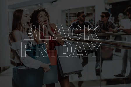 Smiling Girls Are Shopping At The Mall. Black Friday Sale.の写真素材
