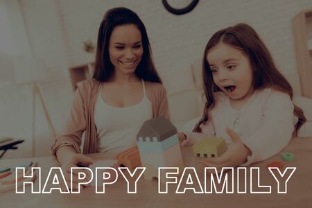 Happy Family. Mom and Daughter Play Educational Games. Mother Teaches Daughter. Learning Child at Home. Cost House of Cubes.の写真素材