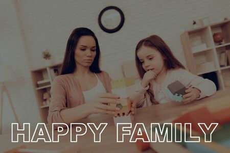 Happy Family. Mom and Daughter Collect Colors Cubes at Home. Mother Teaches Daughter. Educational Games.の写真素材