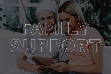 Family Support. Sick Mother and Daughter on Sofa. Mature Sick Woman and Young Beautiful Girl Reading Book Together. Patient with Cancer in Hospital. Healthcare and Family Conceptの写真素材