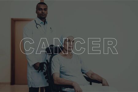 Cancer Treatment. Doctor Helps Woman in Wheelchair. Professional Afro american Doctor in White Coat Helping Sick Female Patient. Healthcare and People Concept. Upset Senior Woman in Hospitalの写真素材