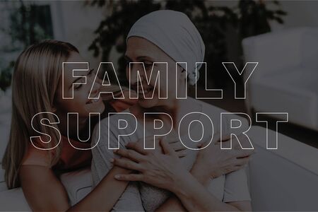 Family Support. Young Daughter Hugging Sick Mother. Mature Sick Woman and Young Beautiful Girl Sitting on Sofa and Hugging. Patient with Cancer in Hospital. Love, Healthcare and Family Conceptの写真素材