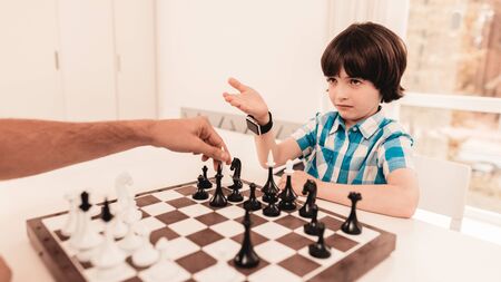 Bearded Father and Son Playing Chess on Table. Happy Family Concept. Board on Table. Young Boy in Shirt. Indoor Joy. Board Games Concept. Modern Hobby Concept.の写真素材