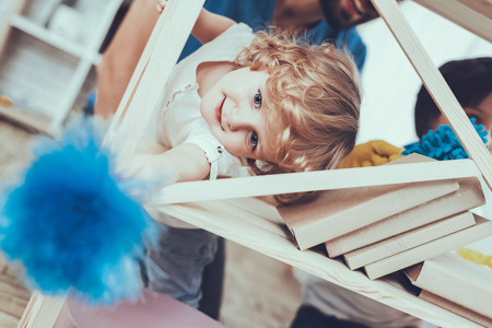 Man Spends Time with His Sons. Father of Boys is Engaged in Raising Children. Father is Teaching a Sons a Cleaning. Father and Sons Wipe the Furniture Surfaces from Dust. People is Located in Bedroom.の写真素材