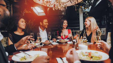 Group of Happy Friends Meeting and Having Dinner. Celebrating with Friends. Party Dinner Table. Enjoying Meal In Restaurant. Restaurant Chilling Out Classy Lifestyle Reserved Concept.の写真素材
