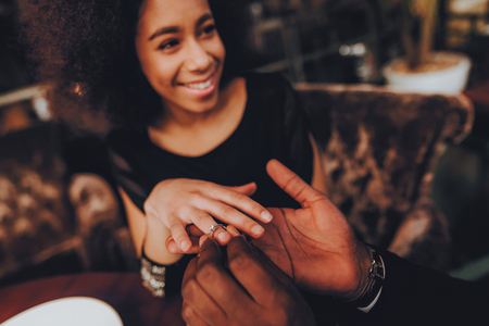 African Handsome Man Proposing to Girlfriend. Romantic Couple in Love Dating. Cutel Man and Girl in a Restaurant. Romantic Concept. Surprised Attractive Woman Getting a Marriage Proposal. Ring.の写真素材