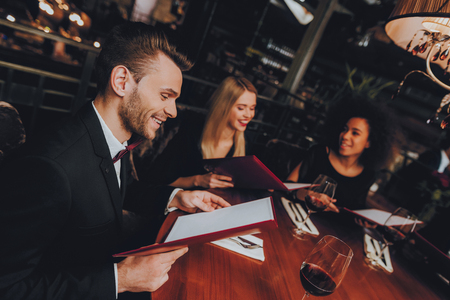 Group Business People Geting Order in Restaurant. Businessmans Having Meeting In Indoor Restaurant. Corporate, Collaboration Concept. Team Professional Worker. Teamwork. Holding Menu.の写真素材