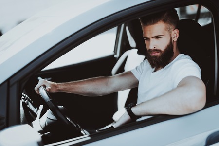 Caucasian Man In The Car. Behind The Wheel Concept. Innovation Technology. New Generation Electro Hybrid Vehicle. Luxury Design. Futuristic Power. Front Seat. Confident Driver.の写真素材
