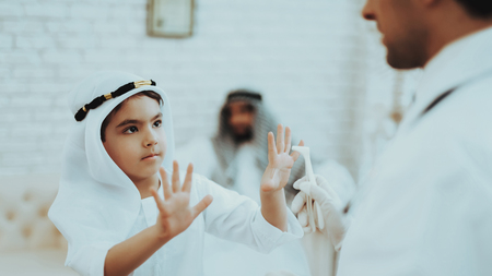 Arabic Male Doctor Examining a Little Boy.の写真素材