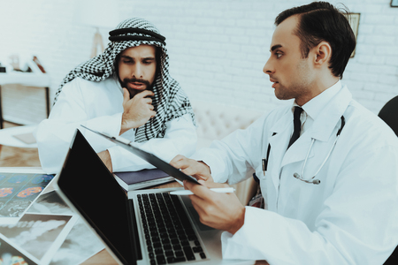 Muslim Man Having Consultiation Doctor Therapist. Young Patient Having Consultation at Clinic. Reception of Therapist. Discussing Diagnosis. Arabic Male Doctor. Examination. Medical Concept.の写真素材