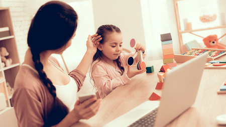 Strokes Little Baby's Head. Educational Games. Learning Child at Home. Child Development. Board Games for Children. Modern Learning for Children. Woman Working on Laptop. Girl Playing Educational Gameの写真素材