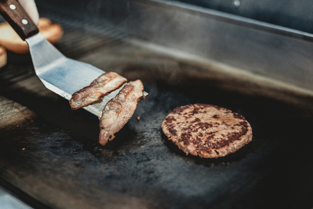 Close up. Worker Cooking Burger in Food Truck. Street Food Concept. Food in Town. Selling Snacks. Preparation of Sandwich. Unhealthy Food. Hands in Gloves. Delicious Hamburder. Rubber Gloves.の写真素材