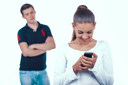 Jealous Husband Looking at Woman with Smartphone.の写真素材