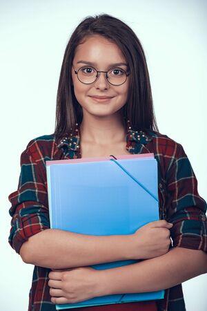 Teenage Schoolgirl in Eyeglasses Holds Books.の写真素材