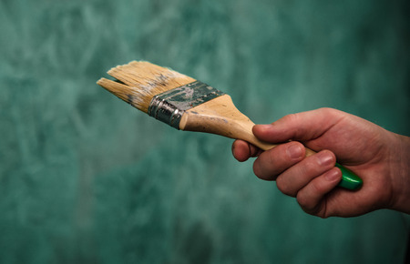 man holding paint brush with green backgroundの写真素材
