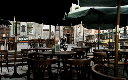 Young and beautiful girls in sunglasses riding a scooter. Portrait of pretty ladies riding a motorbike on old downtown street. Summer vacation. Girls in a black t-shirts on a vintage scooterの写真素材
