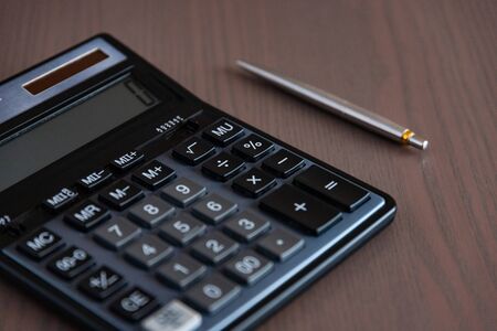 Pen and calculator on business report
