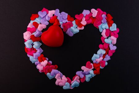 Lots of little hearts in the shape of a heart on a black background