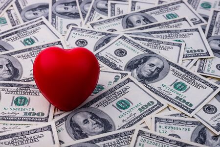 Red heart on a background of dollarsの写真素材
