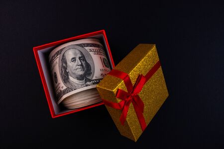 Money in a gift box on a black background.の写真素材