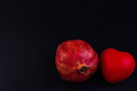 Pomegranate and heart on a dark background.の写真素材