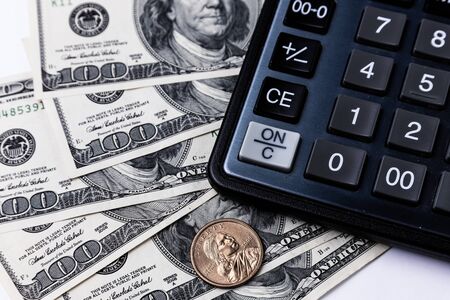 Calculator with dollar and coin on a white backgraundの写真素材