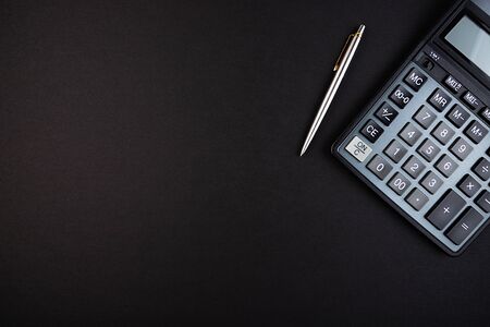 Calculator and pen isolated on a black backgroundの写真素材