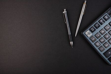 Calculator, pencil and pen isolated on a black backgroundの写真素材