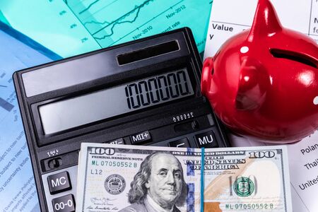 Piggy bank with cash and calculator on business documents background