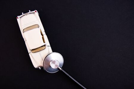 Stethoscope checking up the car on a black background. Concept of car check up, repair and maintenance.の写真素材