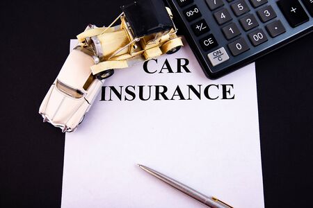 Car insurance concept with calculator on a black tableの写真素材