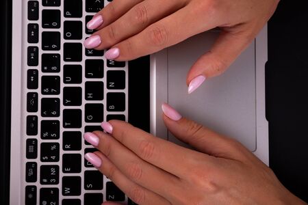 Woman working at home office hand on keyboard close up