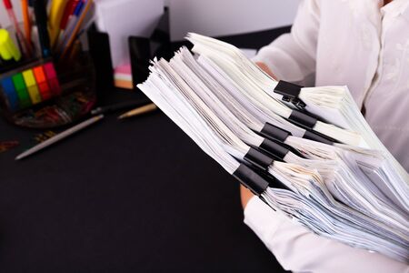 Business woman office workers holding are arranging documents of unfinished documents on office...
