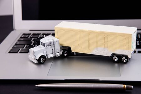 Toy truck and laptop on a black backgroundの写真素材