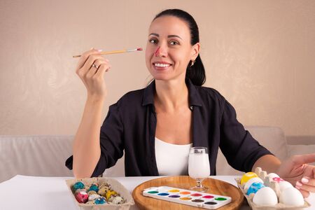 Easter, holidays, traditions and people concept - woman paints easter eggsの写真素材