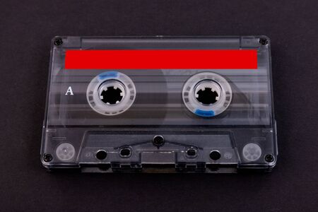 Retro audio cassette tape from the 80s on a black background.の写真素材