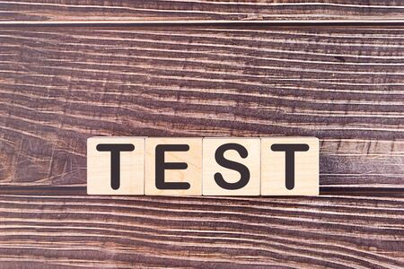 Word TEST made with wood building blocks on a wooden backgroundの写真素材