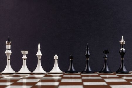 White and black chess pieces on a chessboard on a dark background. Business concept. Game, strategy, wisdom, determination.の写真素材