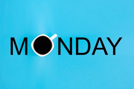 Cup of coffee as letter O in word Monday arranged from print letters on a blue background. Creative minimalist concept.の写真素材