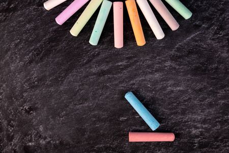 Multicolored chalk on a blackboard laid out in the form of a semicircle.の写真素材