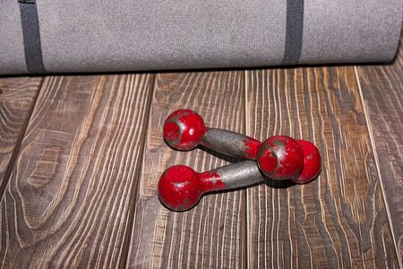 Old sports equipment and floor mat. Fitness or bodybuilding concept background.の写真素材