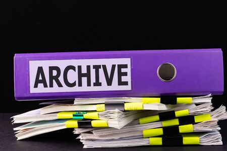 Text, word ARCHIVE is written on a folder lying on documents on an office desk. Business concept.の写真素材