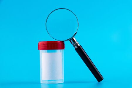 Sterile transparent empty plastic analysis container with magnifier. Red lid Sterile medical...