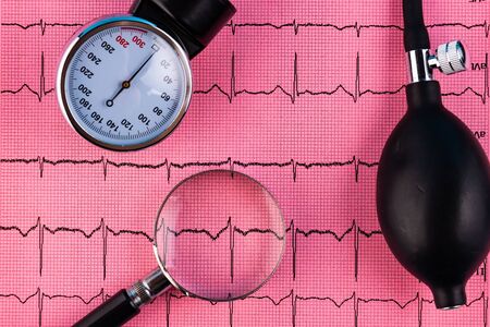 Stethoscope, pressure measuring apparatus and magnifier on the background of a cardiogram.の写真素材