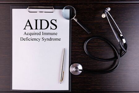 Page with AIDS Acquired Immune Deficiency Syndrome on the table with stethoscope, medical conceptの写真素材