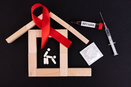 Safe sex health concept. Red ribbon as a symbol of HIV AIDS, blood test, syringe and condom.